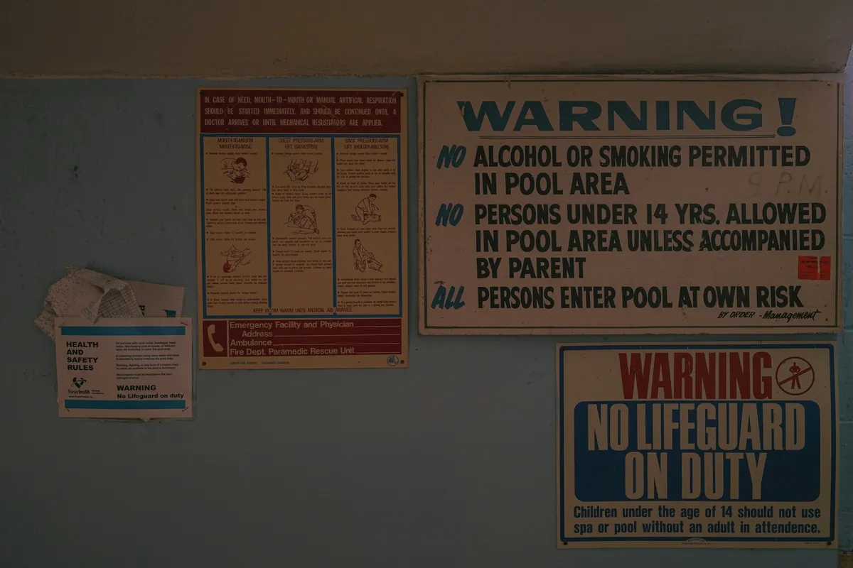 Cluster of yellow and red warning signs mounted on a wall